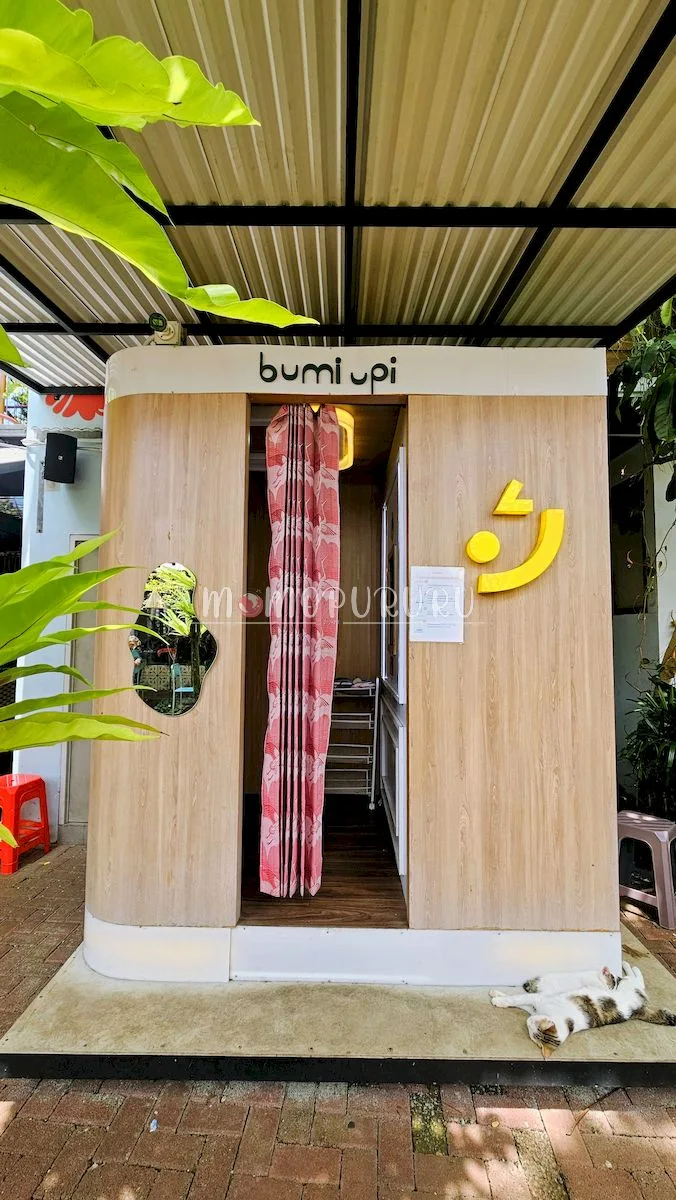 Bilik photobooth Bumi Upi dengan tirai merah dan panel kayu