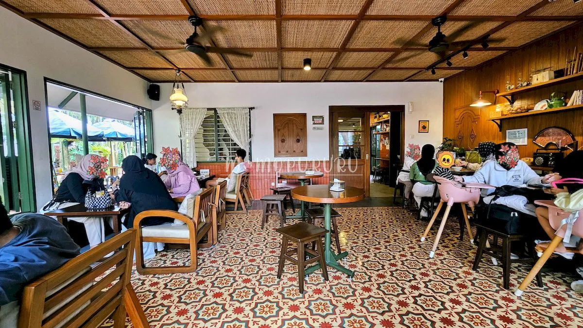 Ruang makan Bumi Upi dengan lantai motif dan perabot kayu